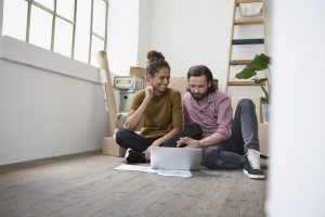 Miami Home Inspectors man and woman sitting on a floor searching something with their laptop