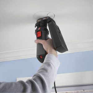 Home Inspector Miami putting whole in the ceilings using home improvement tool