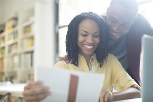 happy couple  looking at a piece of paper - home inspection miami